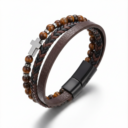 Brown leather and beaded bracelet with a cross charm on a white background