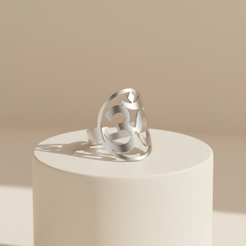Silver ring on a cylindrical white stand with a beige background