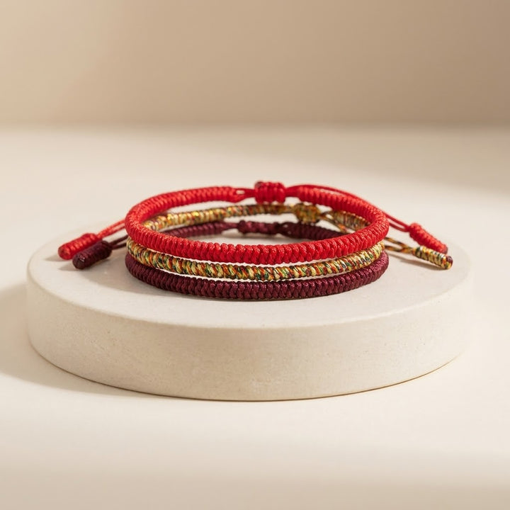 Set of red and gold bracelets on a beige background