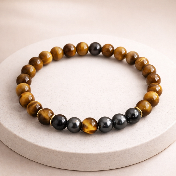 Beaded bracelet with brown, black, and gold beads on a white surface
