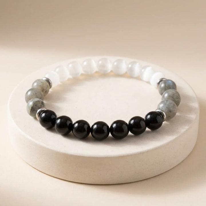 Beaded bracelet with black and gray beads on a white base