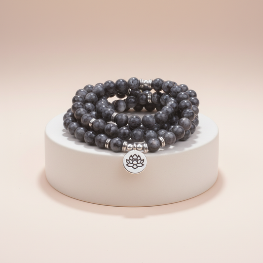 Set of gray beaded bracelets on a white base with a beige background