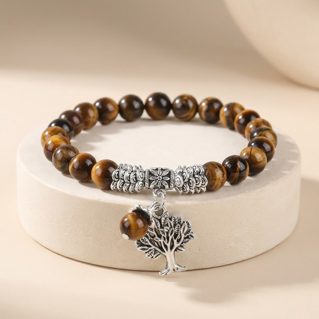 Bracelet with tiger eye beads and tree of life charm on a beige background