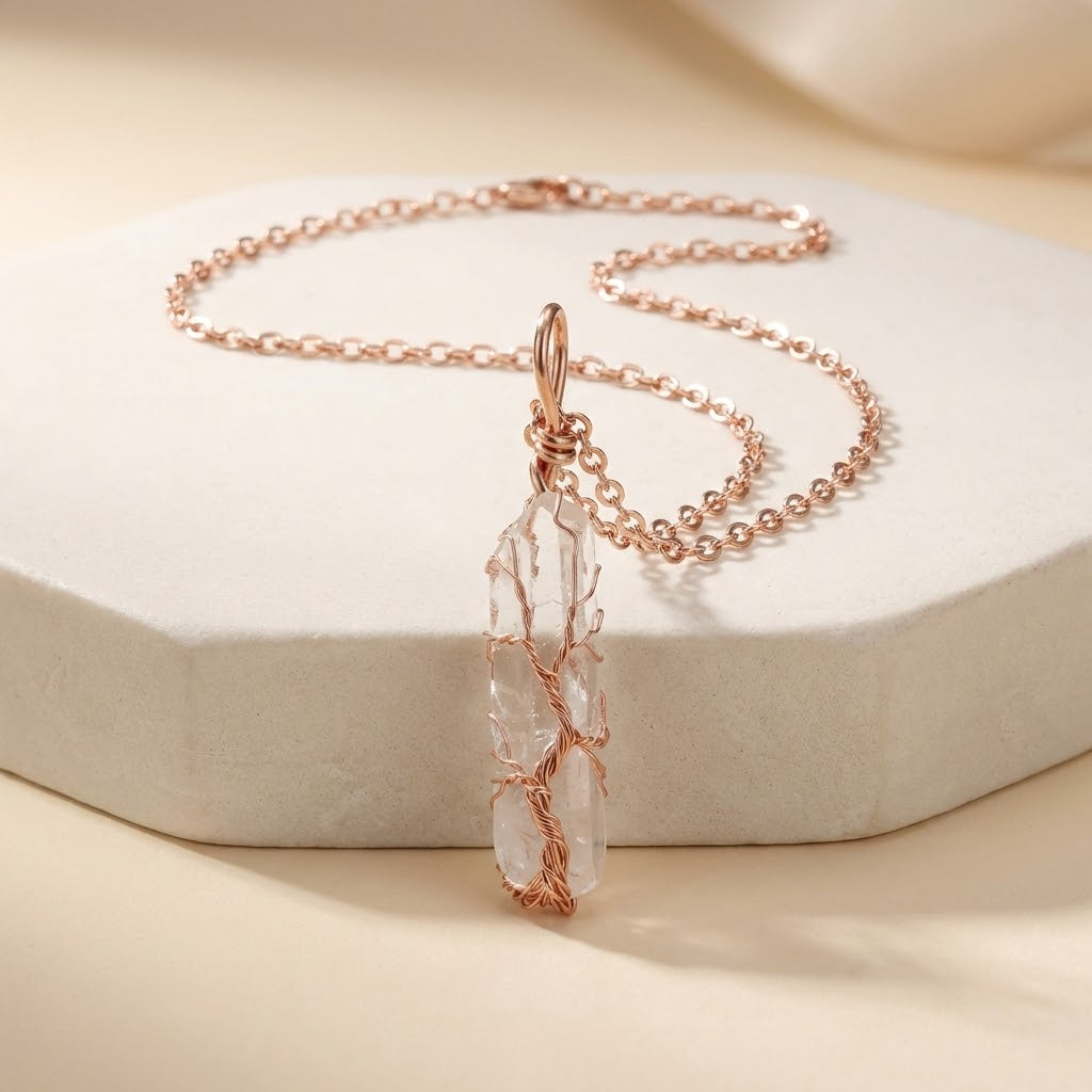 Rose gold necklace with a clear stone pendant on a beige background