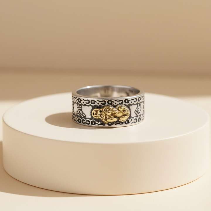 Silver ring with gold accents on a beige background