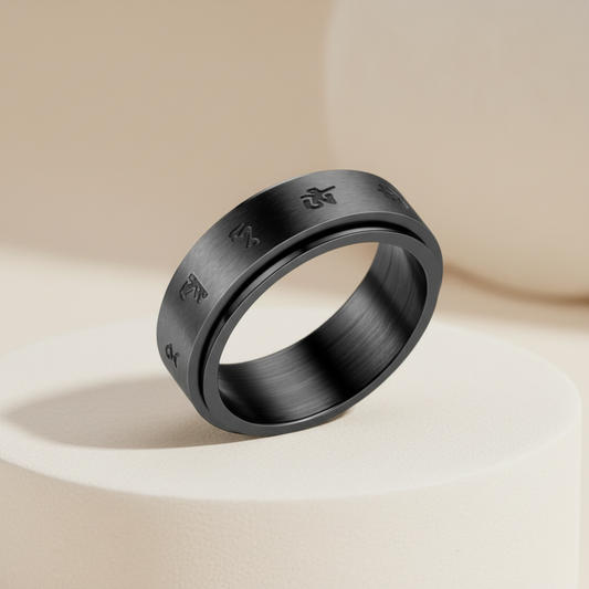 Black ring with engraved symbols on a beige background