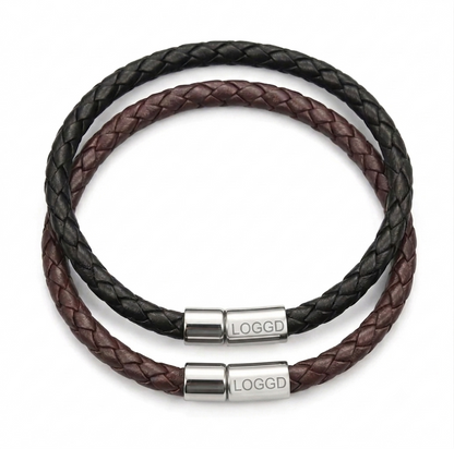 Close-up of a premium minimalist braided leather bracelet for men, featuring a sleek, reflective stainless steel silver clasp.